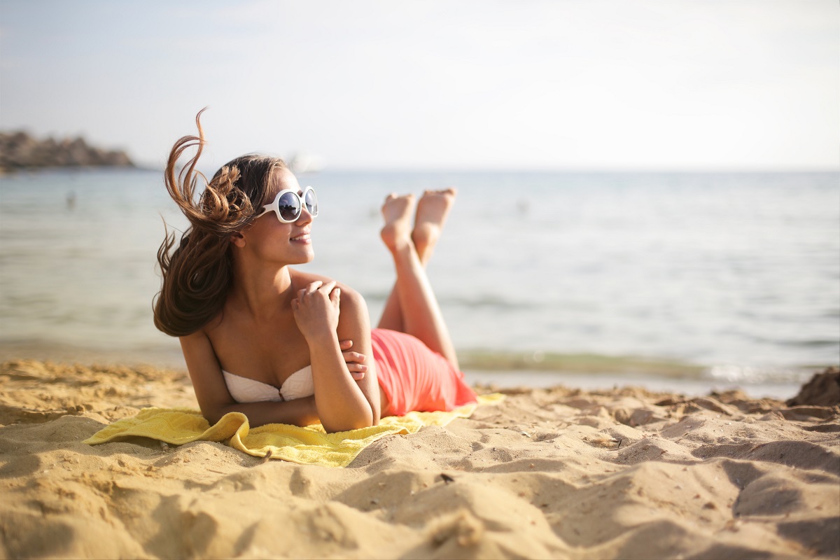 Kobieta na plaży w okularach przeciwsłonecznych - ochrona wzroku